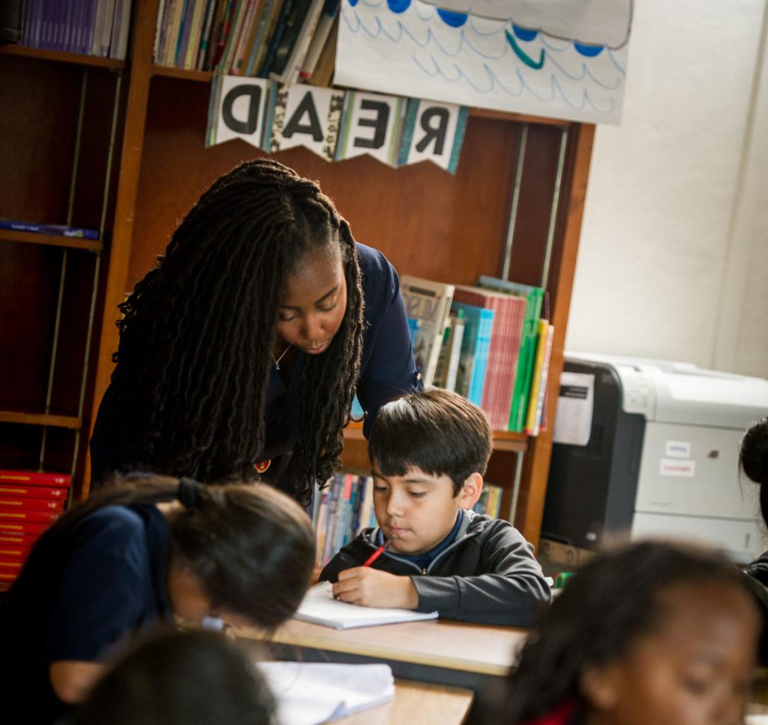 Teacher working with student with additional students in the foreground