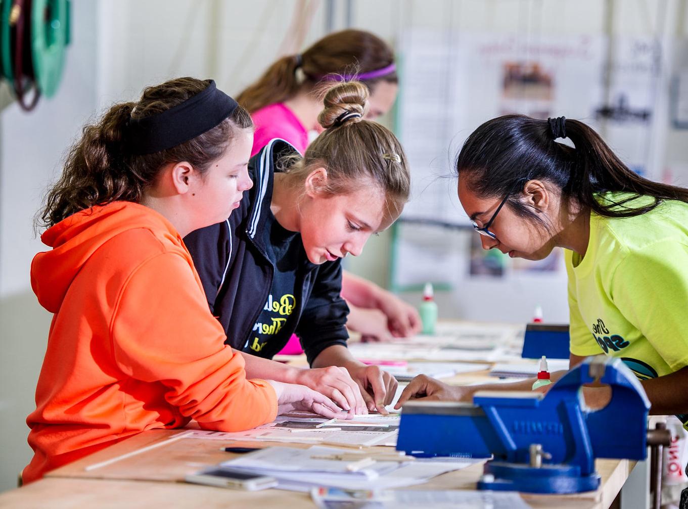 A teacher instructing two middle school students.